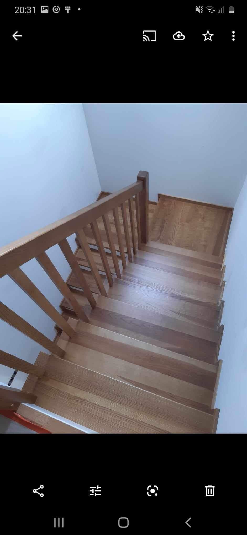 Jasne drewniane schody z prostą balustradą wewnątrz domu, widok z góry.