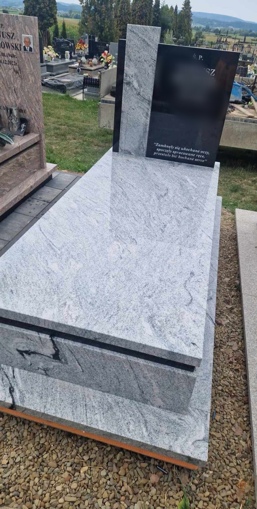 Nowoczesny nagrobek z jasnoszarego granitu z ciemnymi akcentami i wyrytym epitafium, ustawiony na cmentarzu