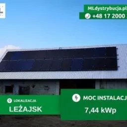Panele słoneczne na dachu budynku gospodarczego w Leżajsku, widoczne logo firmy instalującej i parametry instalacji 7,44 kWp.