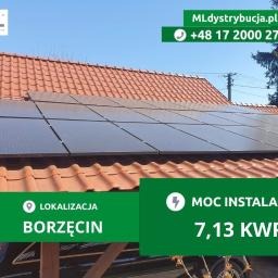 Panel słoneczny na dachu z czerwonej dachówki, widoczne elementy konstrukcyjne, błękitne niebo w tle, reklama firmy z danymi kontaktowymi na zdjęciu.