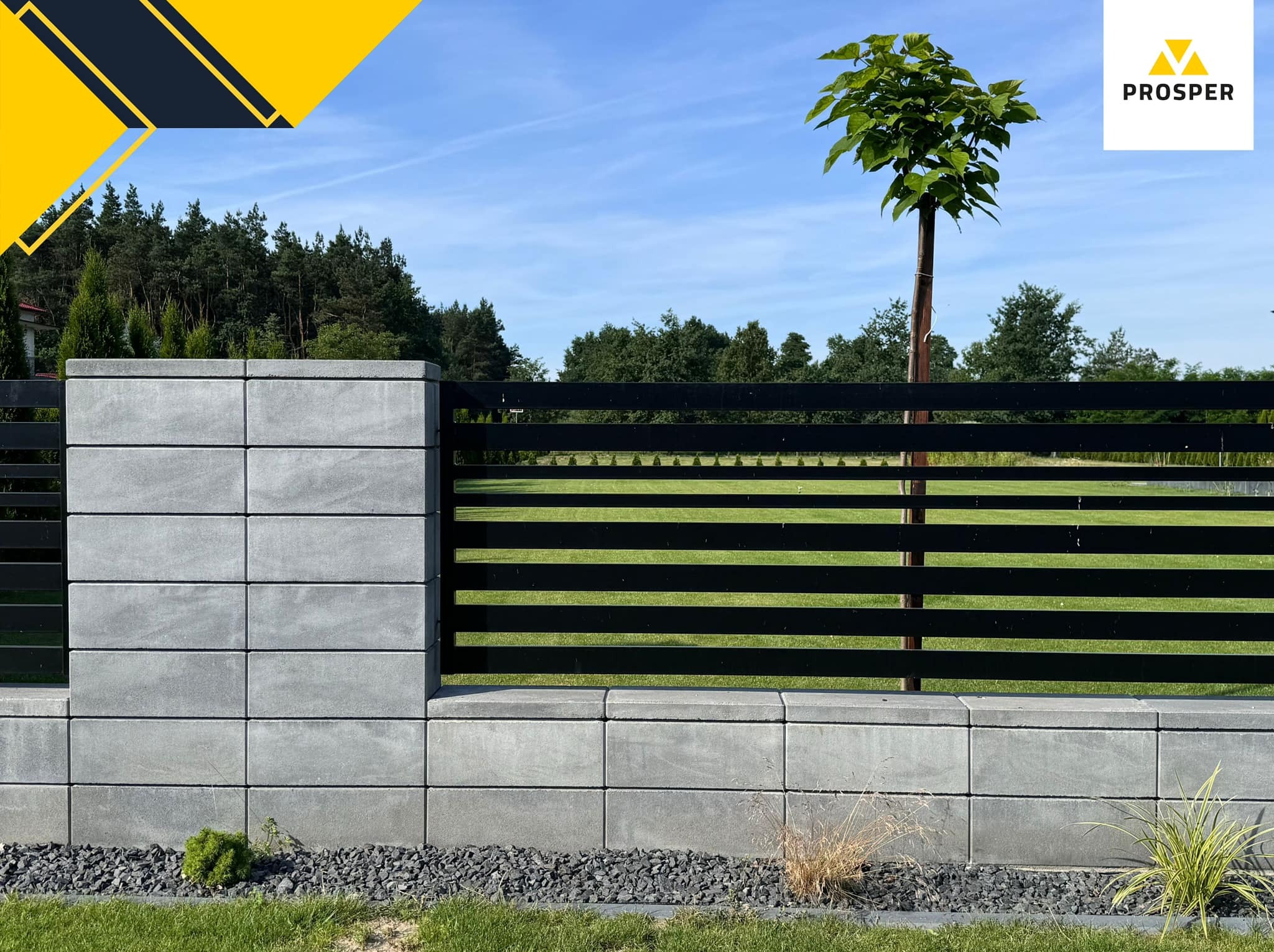 Nowoczesne ogrodzenie z szarej kostki betonowej z czarnymi, poziomymi przęsłami, otoczone ozdobnym żwirem i zielenią, z drzewem w tle i logo firmy Prosper w prawym górnym rogu.