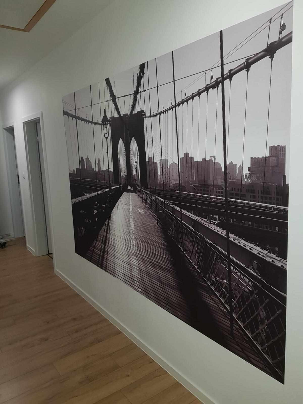 Czarno-biała fototapeta z widokiem na Most Brookliński w korytarzu z panelami podłogowymi.