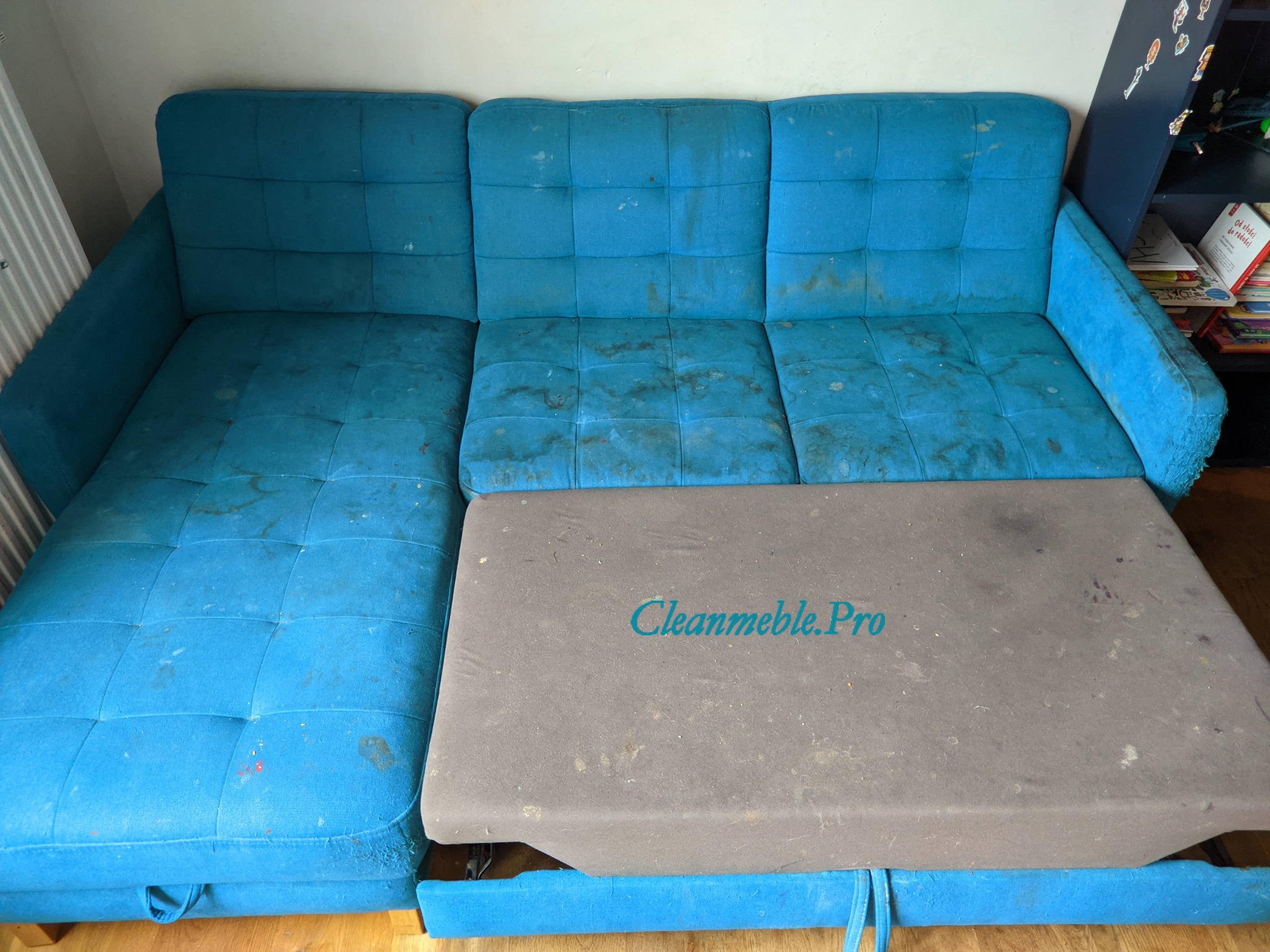 Brudna, rozłożona turkusowa kanapa z widocznymi plamami i zabrudzeniami na siedzisku, z szarym elementem z napisem 'Cleanmeble.Pro'.