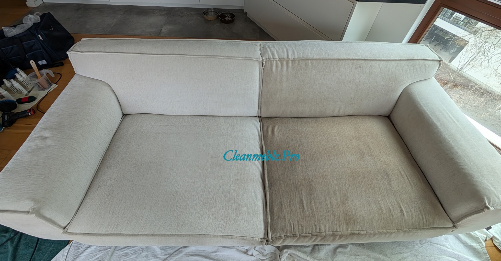 Efekt prania kanapy: Połowa sofy czysta, jaśniejsza, druga połowa brudna, ciemniejsza. Widoczne akcesoria do czyszczenia. Ujęcie z góry, blisko okna.
