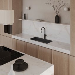 Katarzyna Trzepałka KATYO STUDIO - Minimalistyczna kuchnia z drewnianymi szafkami, marmurowym blatem, czarną armaturą i płytą indukcyjną, oświetlona dwoma kulistymi lampami ściennymi.
