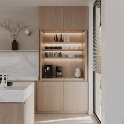 Katarzyna Trzepałka KATYO STUDIO - Nowoczesna kuchnia z wyspą, marmurowym blatem i drewnianymi szafkami, oświetlona półka z ekspresami do kawy i czajnikiem.