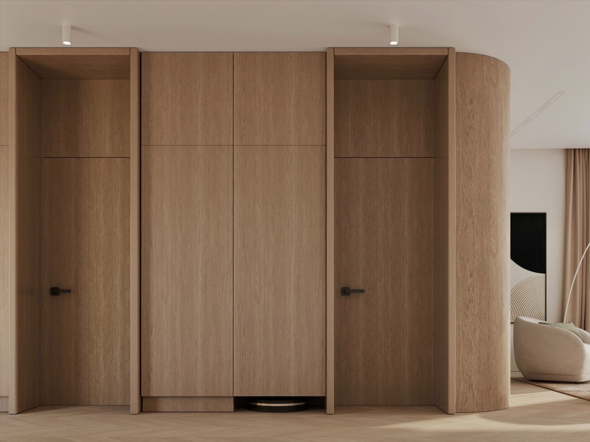 Minimalistyczna zabudowa meblowa z drewna w odcieniach beżu, z ukrytym robotem sprzątającym, w jasnym wnętrzu z parkietem w jodełkę i zaokrąglonym narożnikiem ściany