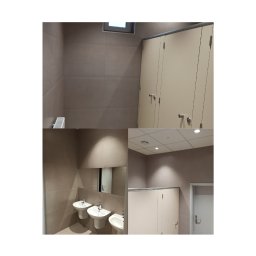 Patryk Cieślak - Wyremontowana łazienka w szkole: beżowe płytki gresowe na ścianach i podłodze, kabiny WC z jasnymi drzwiami, podwieszany sufit Thermatex i umywalki.