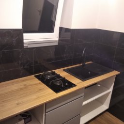 Patryk Cieślak - Kuchnia w czerni oraz brązie na podłodze