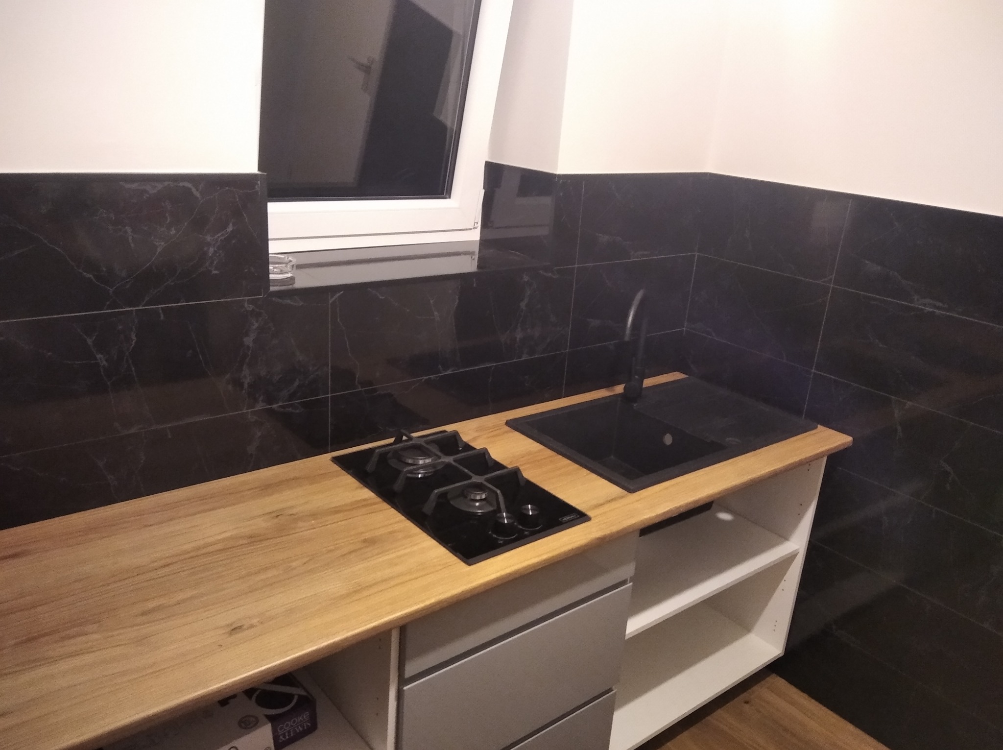 Kuchnia w czerni oraz brązie na podłodze