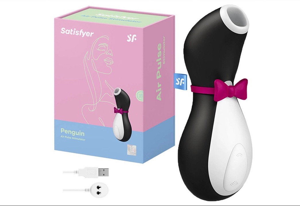 Satisfyer Penguin Air Pulse Stimulator z pudełkiem, kablem USB i wtyczką, na białym tle.