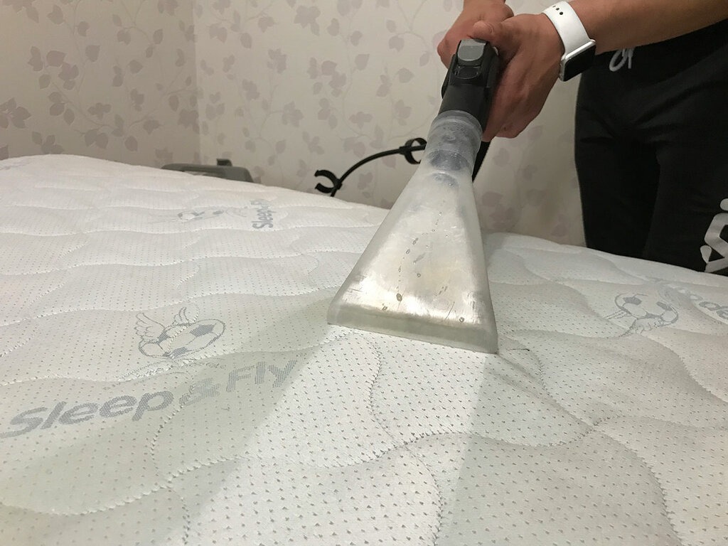 Ekstrakcyjne czyszczenie materaca marki Sleep&Fly z użyciem przezroczystej końcówki odkurzacza piorącego, widoczne ślady wilgoci.