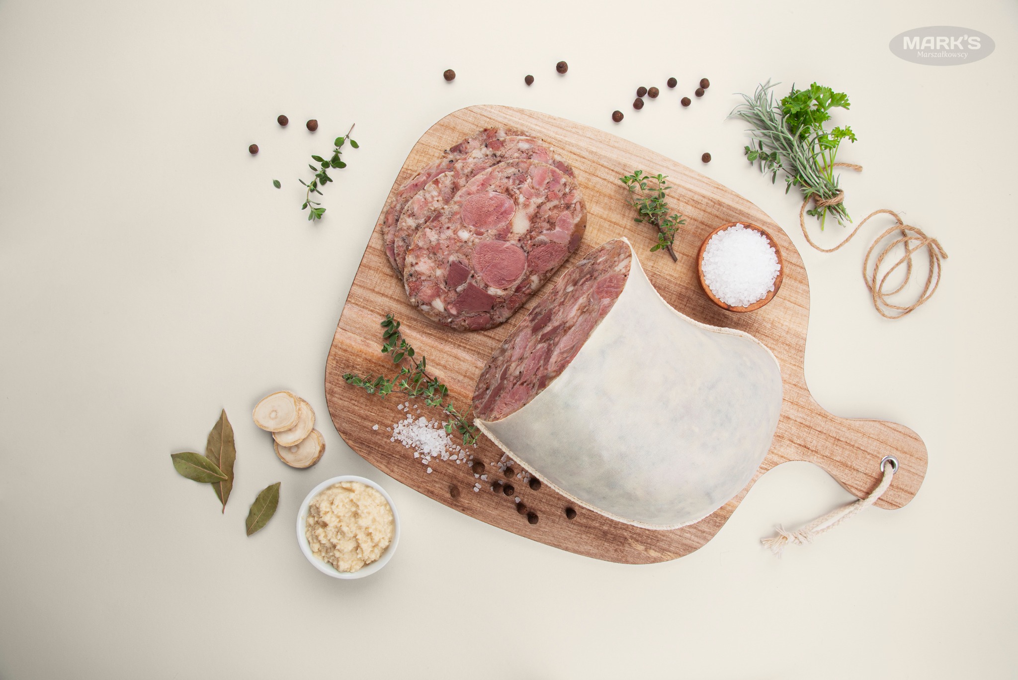 Kaszanka w osłonce i pokrojone plastry na drewnianej desce z przyprawami, z oferty firmy z Sokolnik.