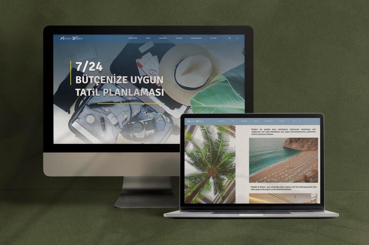 Ekran monitora i laptopa prezentujące stronę internetową biura podróży z motywami wakacyjnymi, w tle walizka, aparat, kapelusz i okulary.