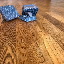 Cyklinomania.pl - Wycyklinowana, lakierowana podłoga z drewna w Rzeszowie z widocznymi narzędziami do cyklinowania, ukazującymi wzór powierzchni.