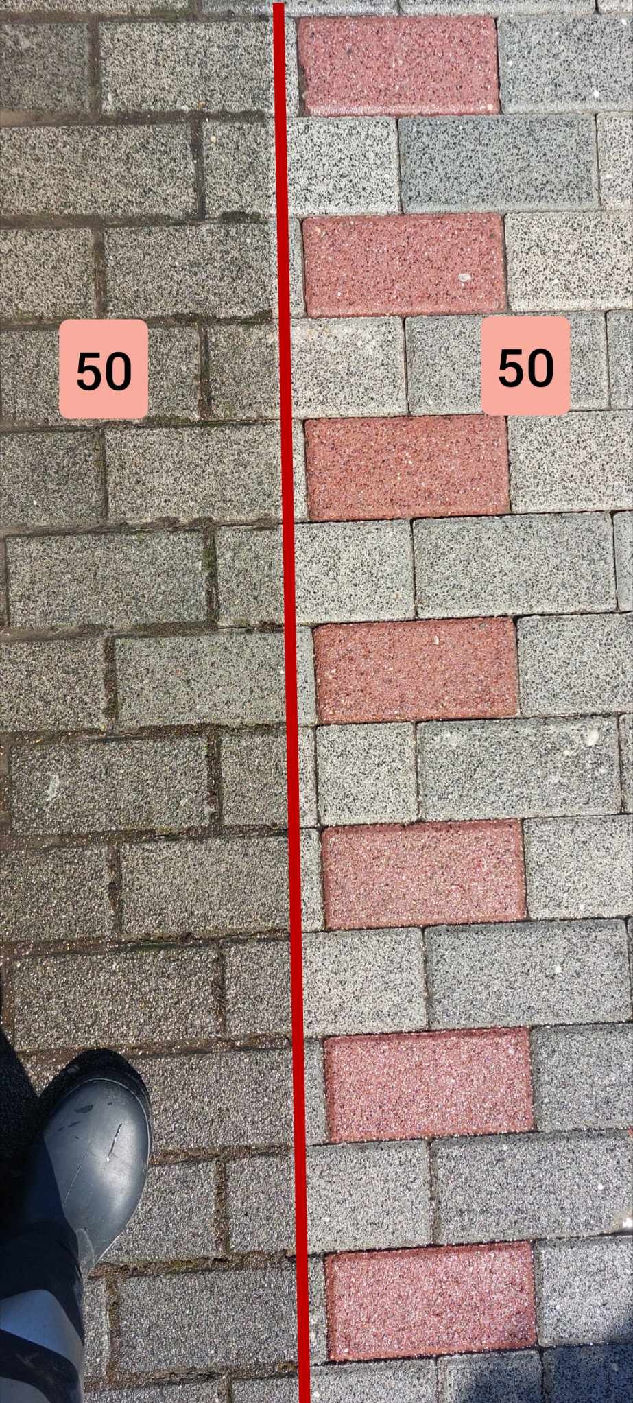 Porównanie powierzchni kostki brukowej przed i po czyszczeniu, rozdzielone czerwoną linią, z widocznym fragmentem gumowca.