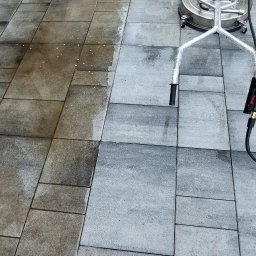 Angelika Liszka Rudy czyścik - Czyszczenie kostki brukowej szorowarką ciśnieniową, widoczna różnica między wyczyszczoną a zabrudzoną powierzchnią.