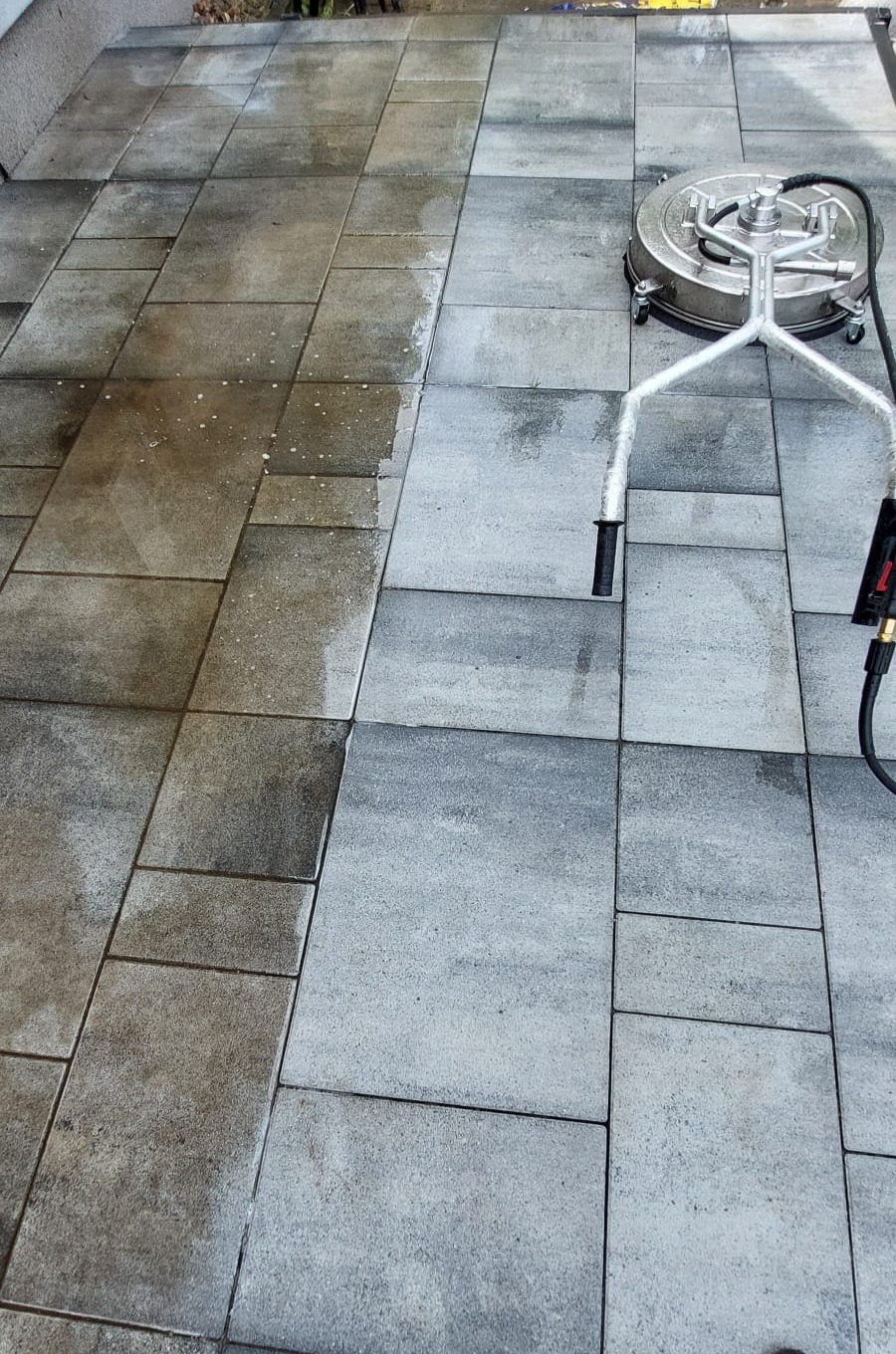 Czyszczenie kostki brukowej szorowarką ciśnieniową, widoczna różnica między wyczyszczoną a zabrudzoną powierzchnią.