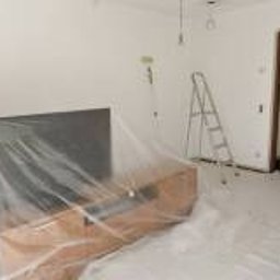 Tomasz Błaszczykowski - Pokój w trakcie odświeżania: świeżo pomalowane białe ściany, meble zabezpieczone folią, drabina, pędzle i wiaderka z farbą na podłodze. Widoczne niedoskonałości malarskie przy futrynie drzwi.