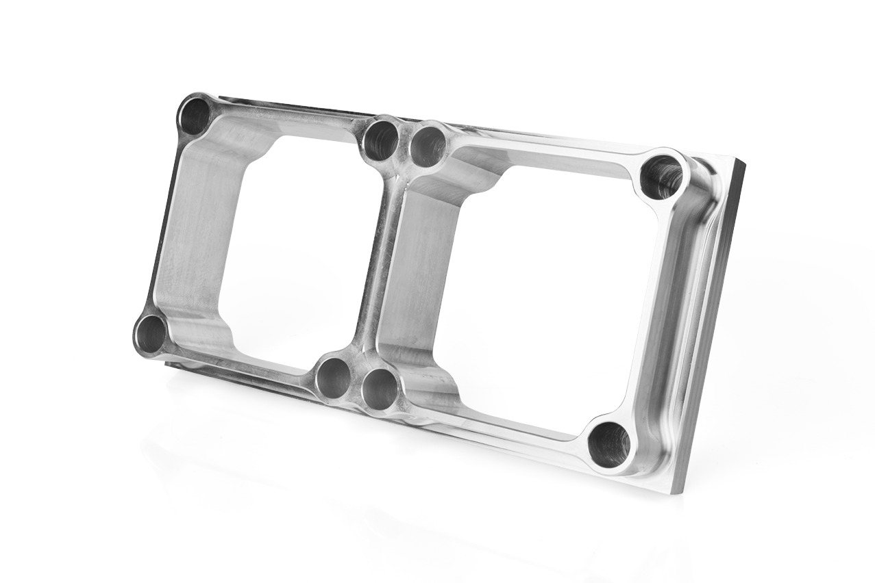 Precyzyjnie obrobiony, aluminiowy element z dwoma kwadratowymi otworami i licznymi okrągłymi otworami montażowymi, sfotografowany na białym tle z subtelnym cieniem.