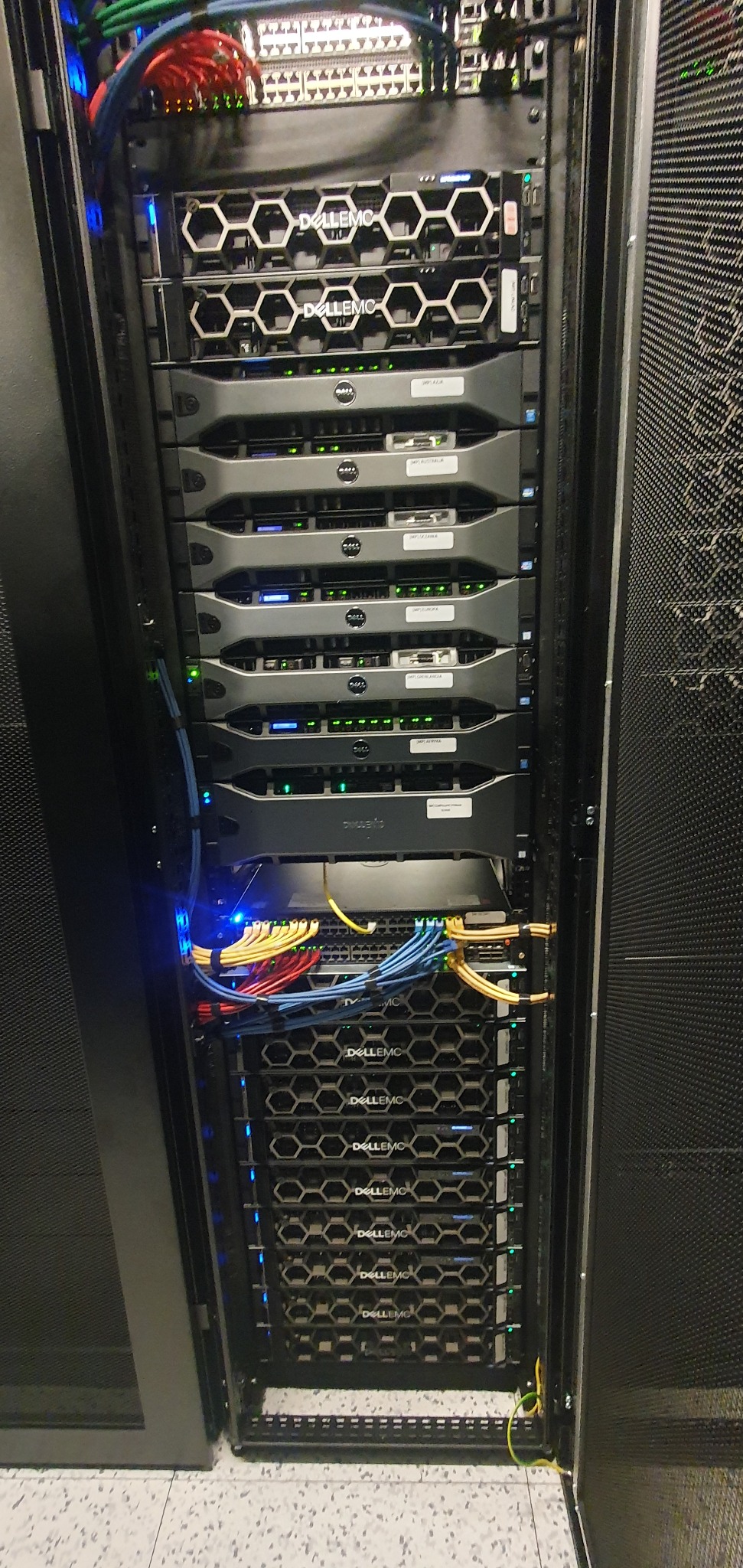 Rząd serwerów Dell EMC w szafie rack, z widocznymi kablami i diodami LED, prezentujący infrastrukturę IT gotową do pracy.