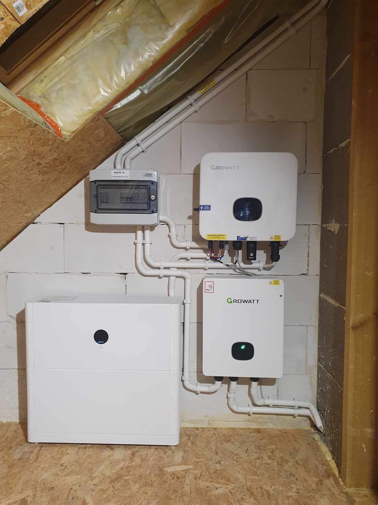 Kompletny system fotowoltaiczny Growatt z magazynem energii, zamontowany w pomieszczeniu z surowymi ścianami z bloczków i drewnianą podłogą.