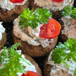 Catering & Cooking Corner - Zbliżenie na kanapki z pastą, pomidorem i natką pietruszki, ułożone na czarnej tacy.