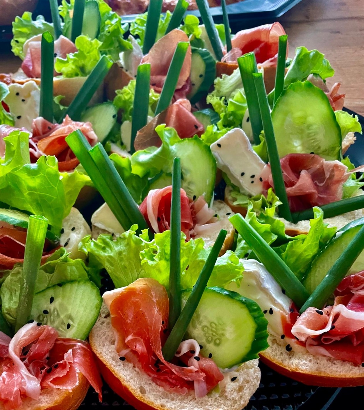 Kanapeczki z szynką parmeńską, sosem śmietanowym, camembertem, ogórkiem, sałatą i czarnuszką