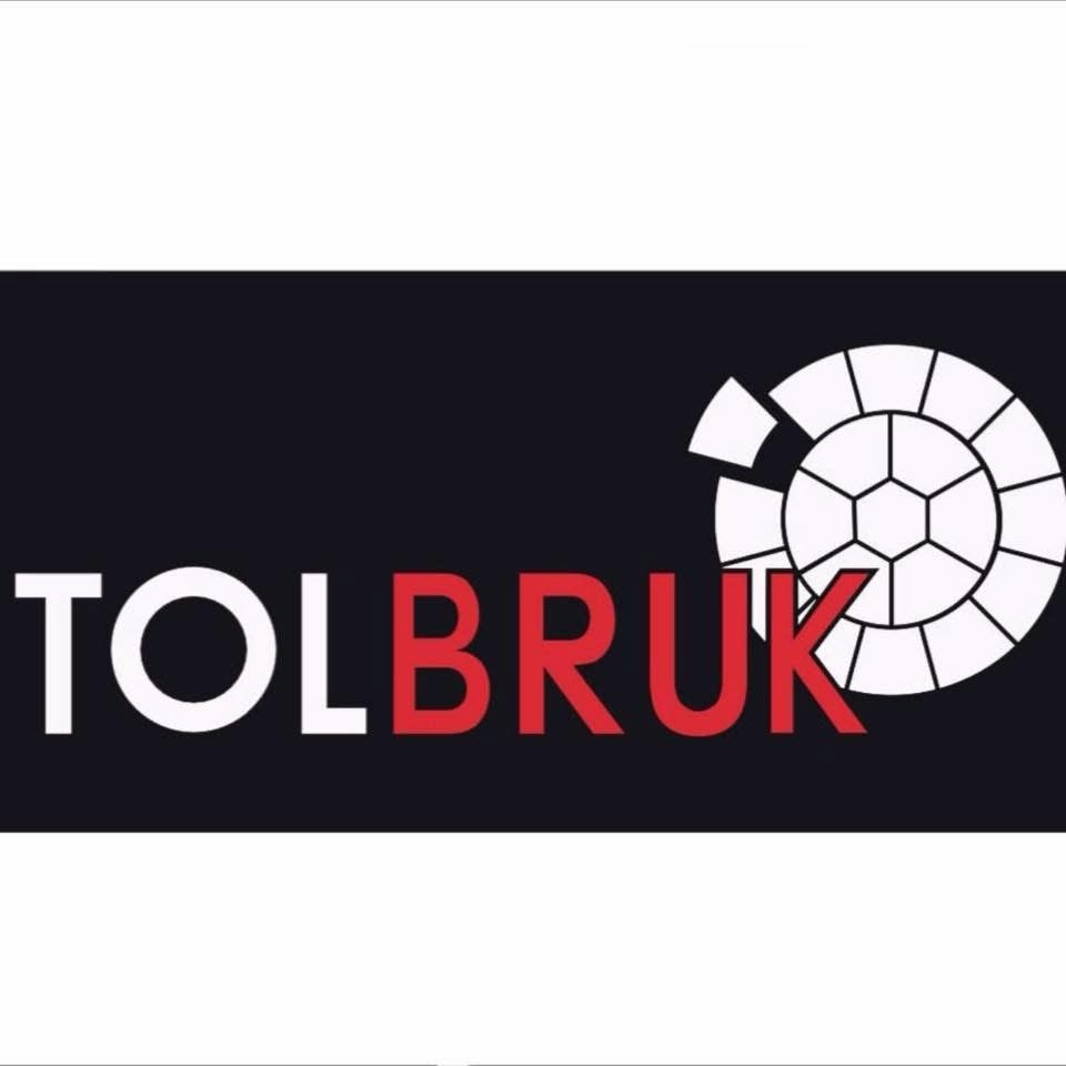 Logo firmy TOLBRUK z nazwą w kolorach białym i czerwonym oraz graficznym symbolem kostki brukowej w formie koła z brakującymi elementami.