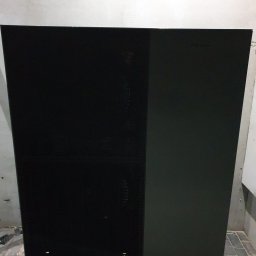 Tompor - Czarno-szara, dwuczęściowa obudowa pompy ciepła marki Viessmann, stojąca na betonowej posadzce, widoczna z przodu.