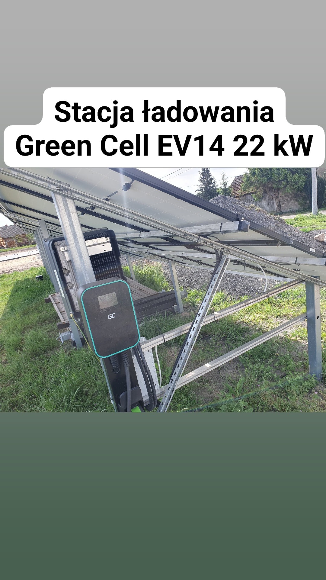 Stacja ładowania Green Cell EV14 22 kW zamontowana pod konstrukcją paneli fotowoltaicznych na trawiastym terenie.