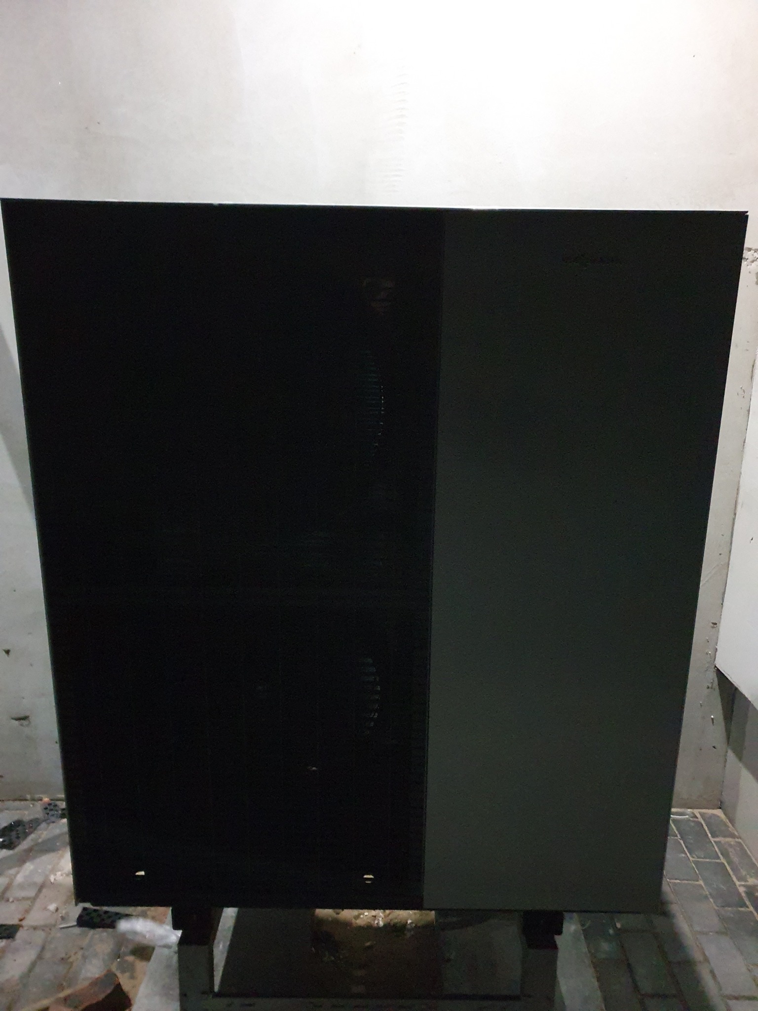 Czarno-szara, dwuczęściowa obudowa pompy ciepła marki Viessmann, stojąca na betonowej posadzce, widoczna z przodu.