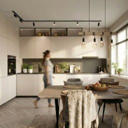 Julia Dujka Interior Design - Nowoczesna kuchnia z jadalnią: minimalistyczne białe szafki, drewniany regał na wino z podświetleniem LED, stół z owocami i dekoracyjne panele ścienne.