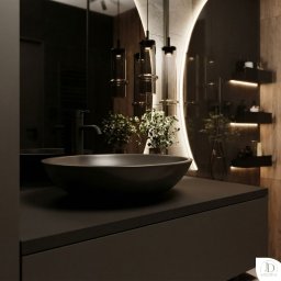 Julia Dujka Interior Design - Nowoczesna łazienka z umywalką nablatową, czarną armaturą i podświetlanym lustrem. Minimalistyczny design z drewnianymi akcentami i roślinami.