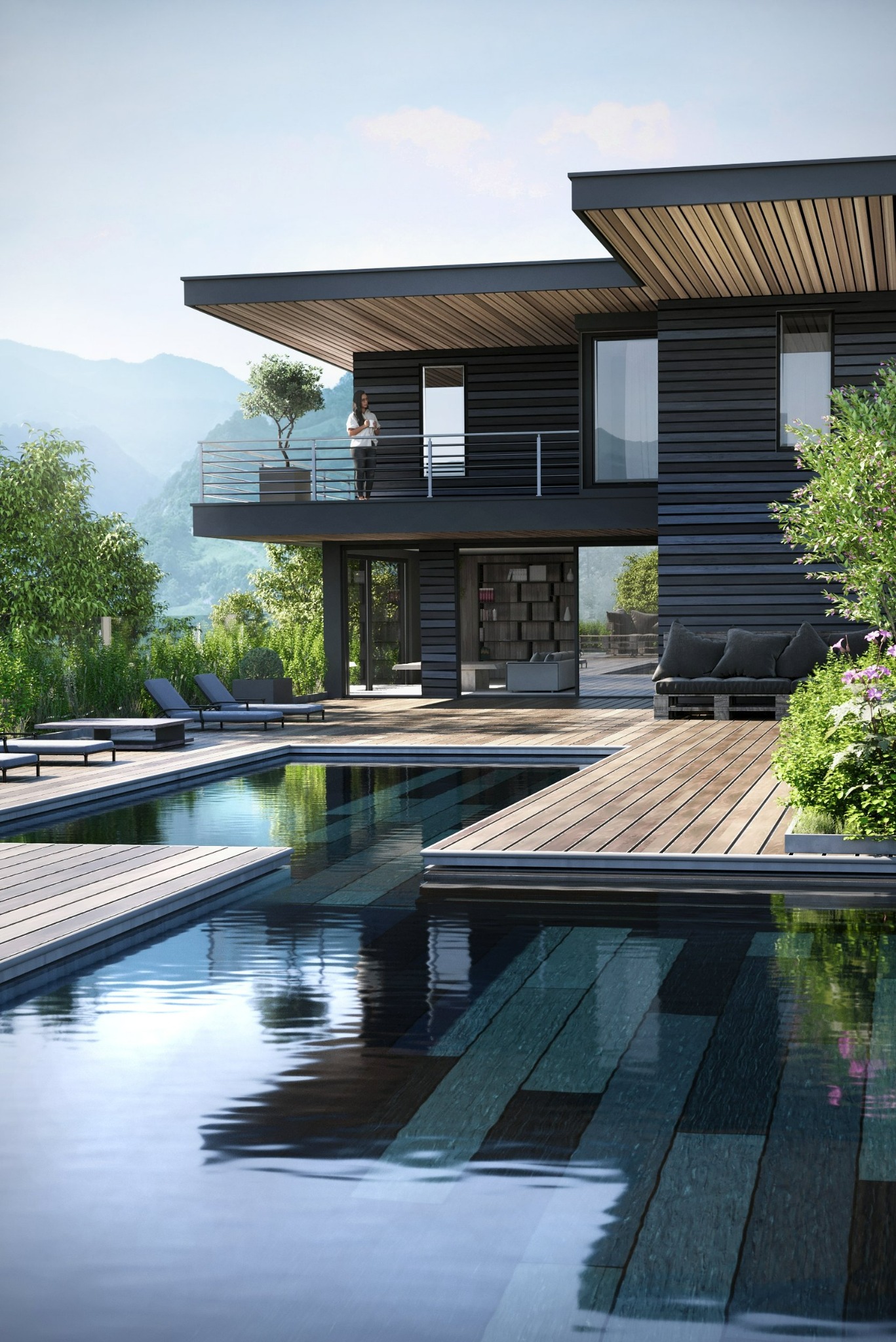 Nowoczesny dom z płaskim dachem i czarną elewacją, basen z drewnianym pomostem, kobieta na balkonie z widokiem na góry w tle.