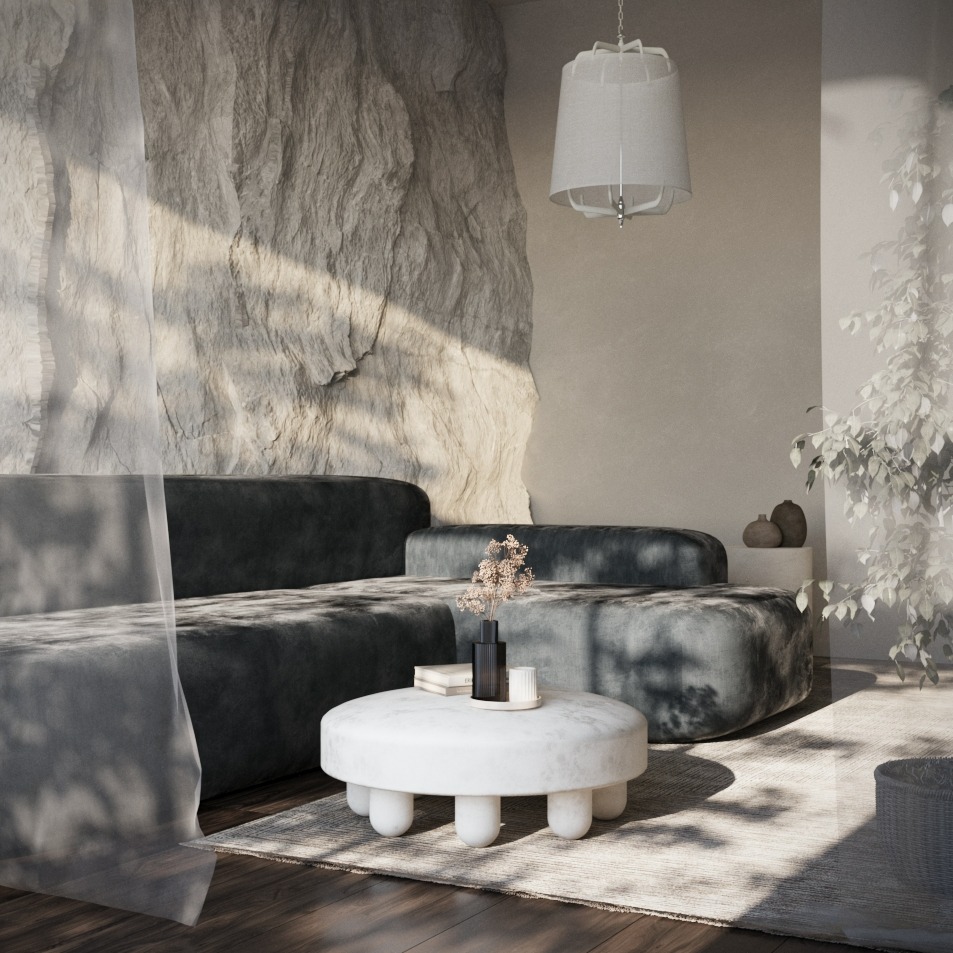 Stylowy salon z modułową sofą w odcieniach szarości, okrągłym stolikiem kawowym i dekoracyjną ścianą z kamienia. Naturalne światło podkreśla minimalistyczny design.