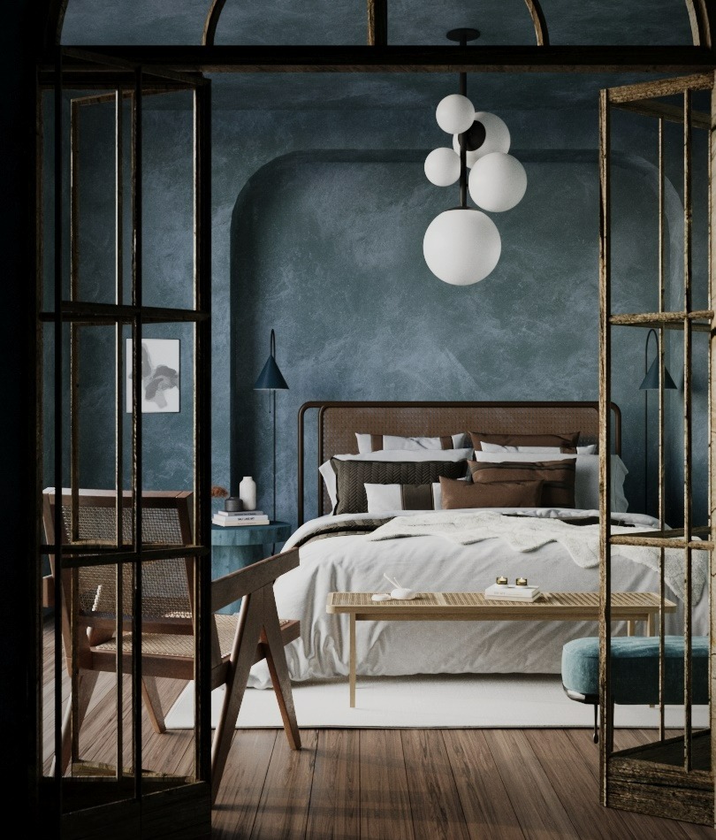 Stylowa sypialnia w odcieniach błękitu z drewnianą podłogą i rattanowymi elementami. Widoczne łóżko, krzesło i lampa kulista. Ujęcie przez ażurowe drzwi.