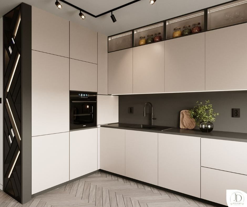 Minimalistyczna kuchnia w bieli i szarości z drewnianą podłogą w jodełkę. Górne szafki z podświetleniem i dekoracyjnymi słoikami. Czarny piekarnik i bateria.