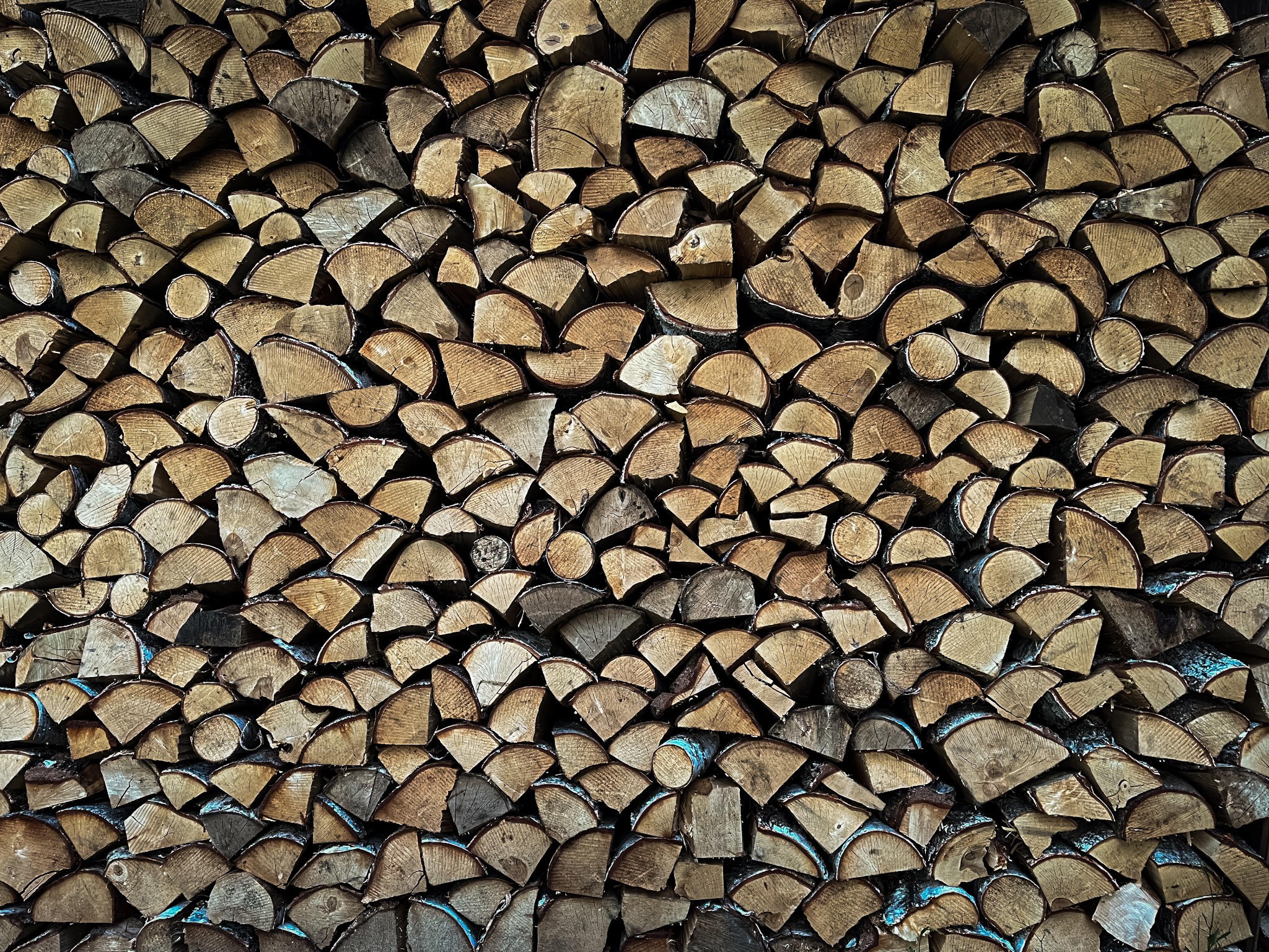 Starannie ułożony stos pociętych kawałków drewna w Grzawie, ukazujący naturalne słoje i korę.
