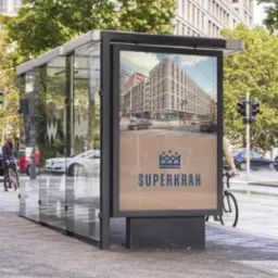 Przystanek autobusowy z reklamą nowego budynku mieszkalnego w tle ruchliwej ulicy miejskiej.