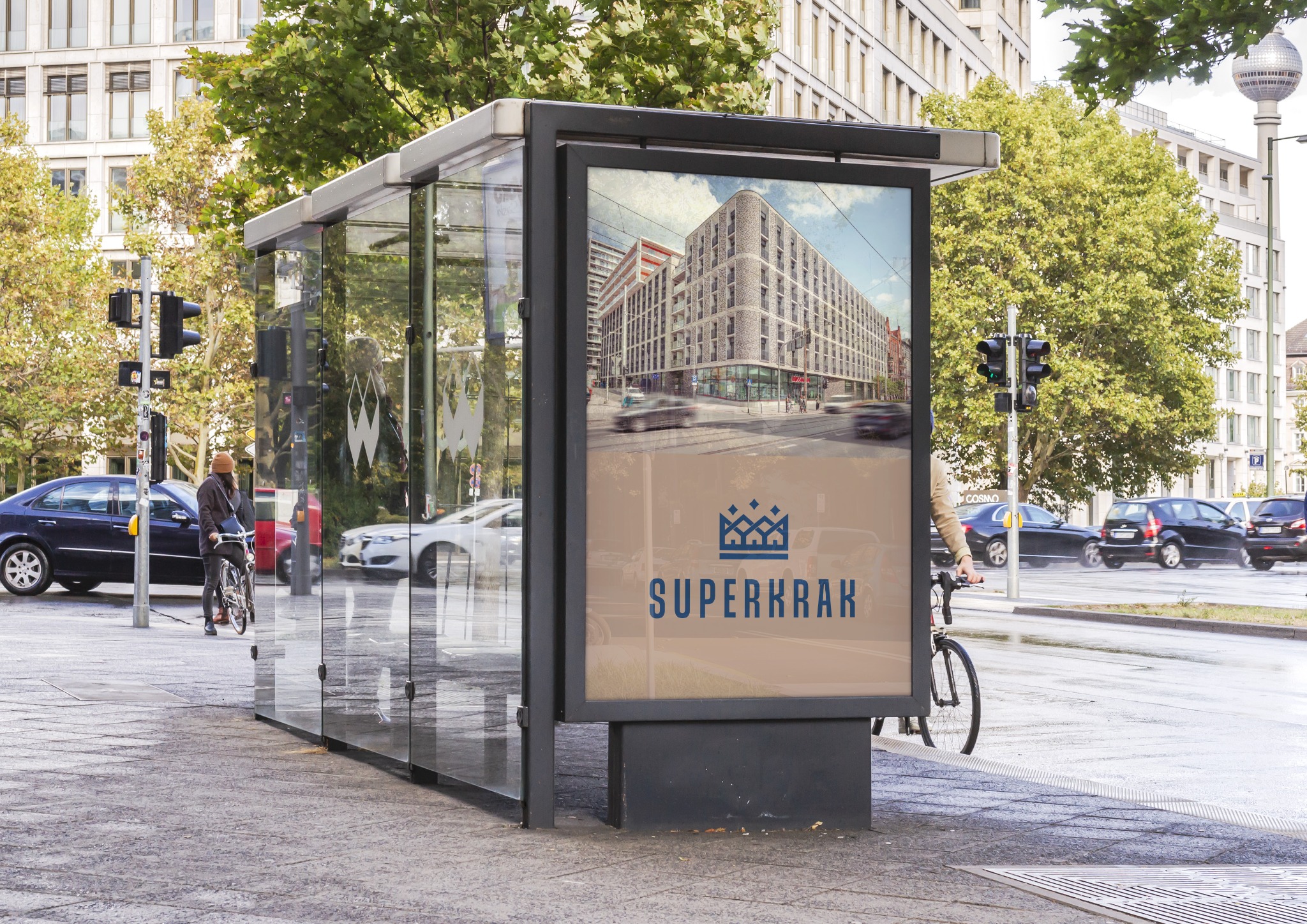 Przystanek autobusowy z reklamą nowego budynku mieszkalnego w tle ruchliwej ulicy miejskiej.