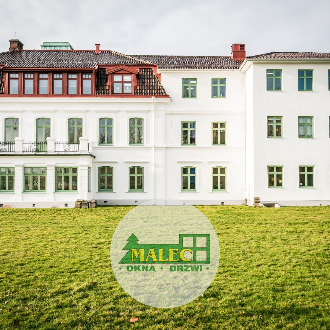 Biały budynek z zielonymi ramami okiennymi, widoczny trawnik i logo firmy nałożone na zdjęcie.