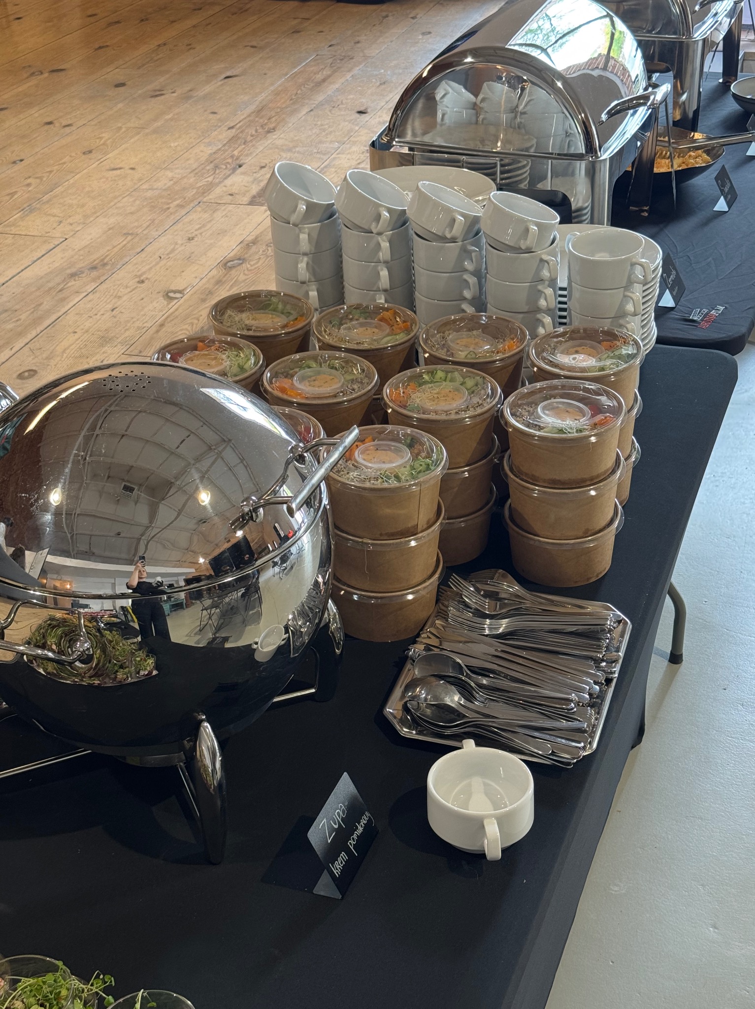 Stół cateringowy w Warszawie: zupy krem w słoiczkach, stosy filiżanek, sztućce i bemary. Profesjonalna obsługa imprez i wydarzeń.