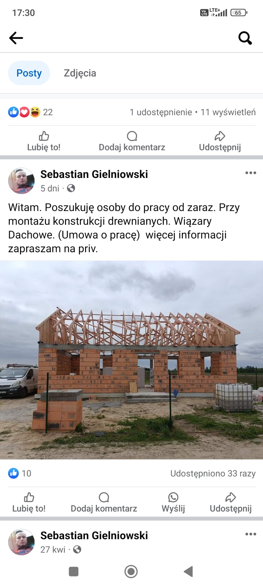Budowa domu jednorodzinnego w trakcie realizacji: murowane ściany z pustaków ceramicznych i drewniana konstrukcja dachu bez pokrycia, widoczny samochód dostawczy i materiały budowlane na działce.