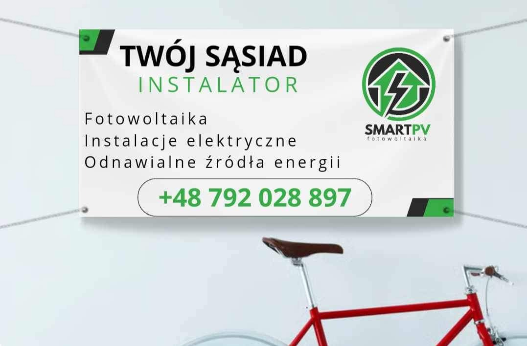 Baner reklamowy firmy instalującej panele słoneczne i instalacje elektryczne, widoczny numer telefonu oraz logo SmartPV, na drugim planie czerwony rower.