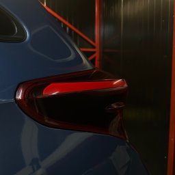 2brodetailing - Błyszczący, niebieski lakier na tylnej części samochodu, z widocznym światłem stopu i elementami konstrukcji w tle.