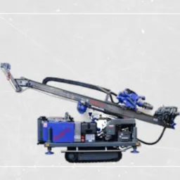 Mobilna wiertnica geotermalna z wysięgnikiem, niebieskimi elementami i logotypem na obudowie, na tle szarej, teksturowanej powierzchni.