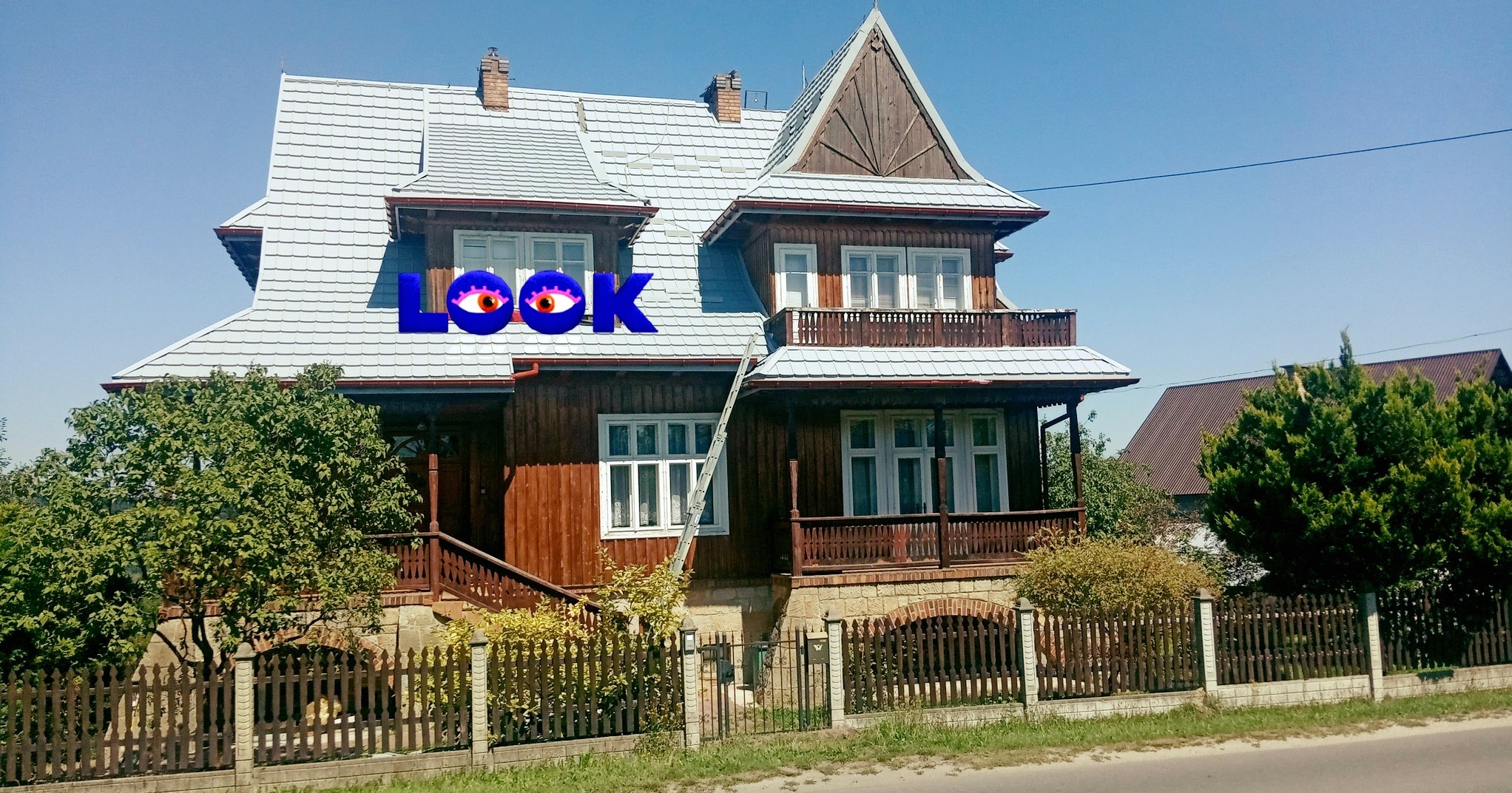 Dwupiętrowy dom z drewnianą elewacją i jasnoszarym dachem, z widoczną drabiną opartą o ścianę, sugerującą prace na wysokości.