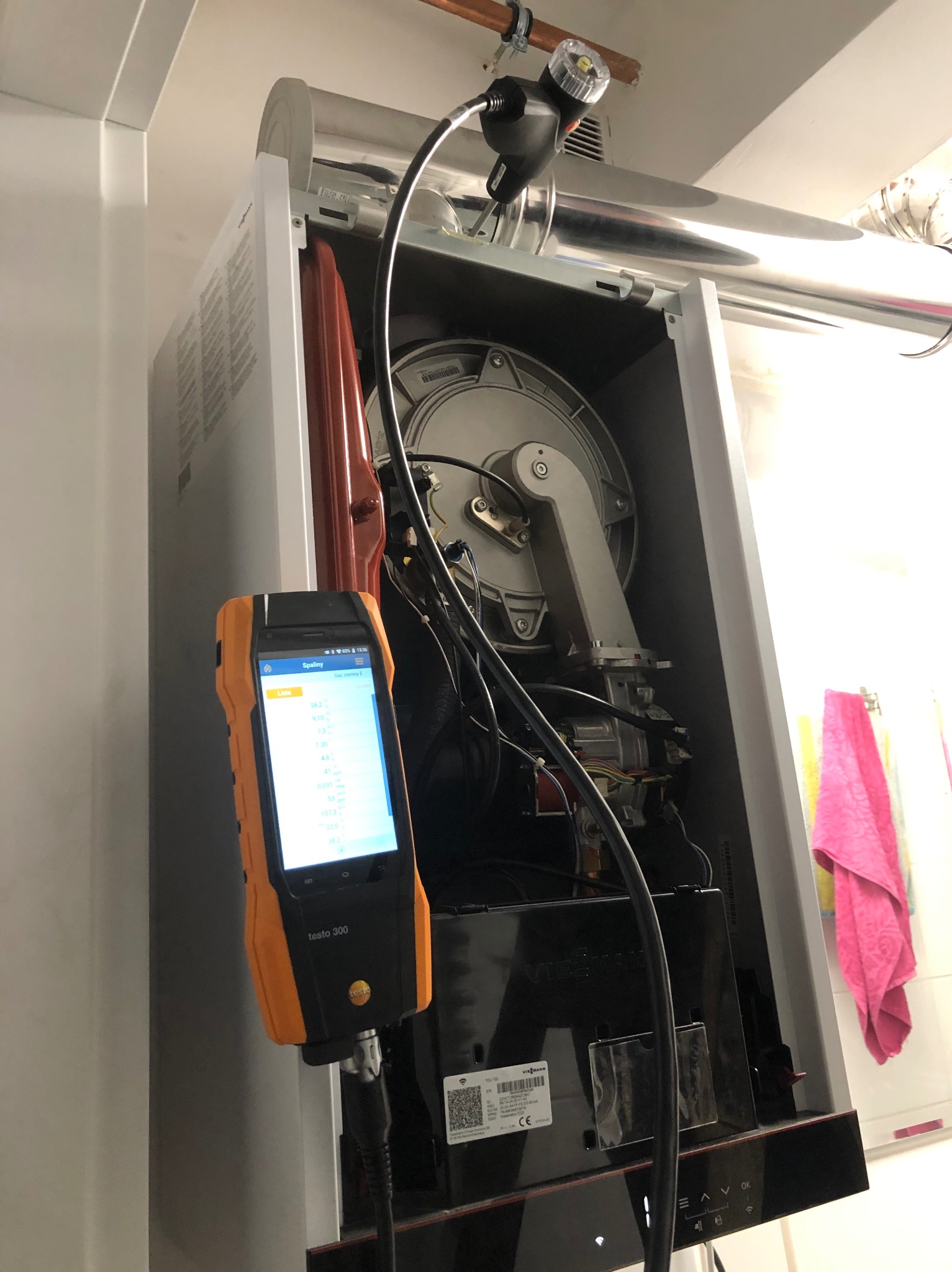 Analizator spalin Testo 300 podłączony do pieca gazowego Viessmann w Katowicach podczas pomiarów, widoczne wyniki na ekranie urządzenia.