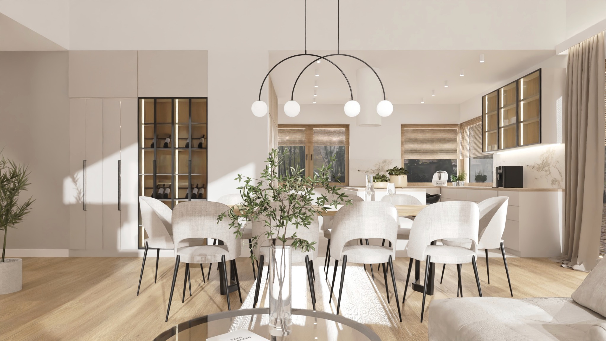 Jasne wnętrze jadalni z drewnianym stołem otoczonym krzesłami w kolorze ecru, nad stołem lampa z czterema kulistymi kloszami, w tle widoczna kuchnia z białymi szafkami i marmurowym blatem, po lewej...